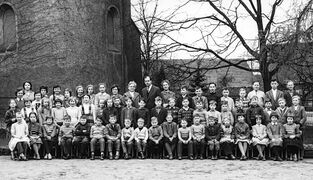 Die Schülerinnen und Schüler mit beiden Lehrkräften auf dem Schulhof (ca. 1960)
